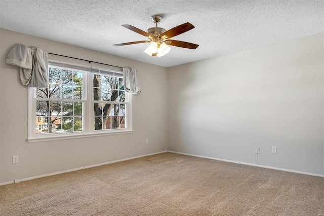 spare room with ceiling fan, a textured ceiling, and carpet flooring