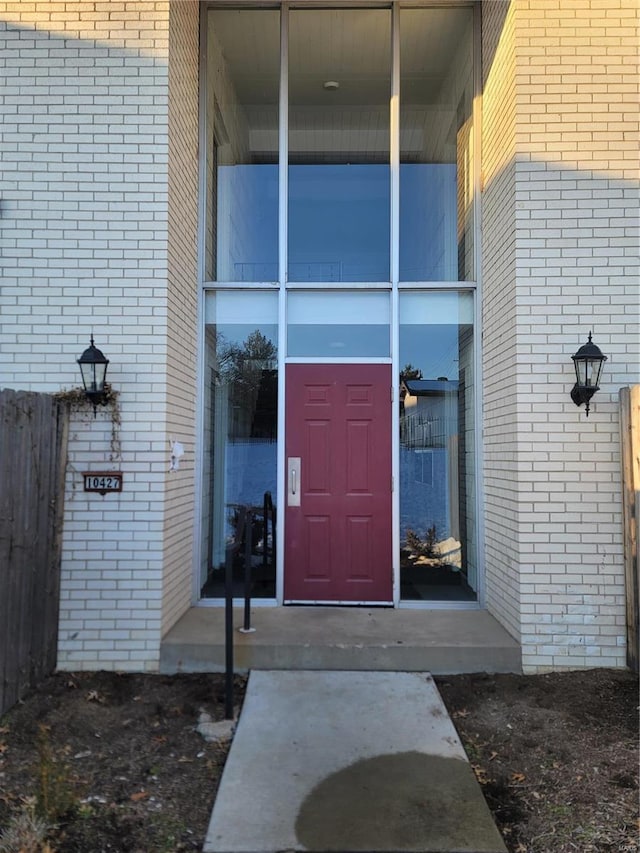 doorway to property featuring brick siding