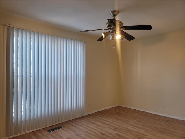 empty room with light wood-style floors, visible vents, and baseboards