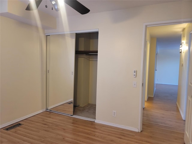 unfurnished bedroom featuring a closet, visible vents, light wood-style flooring, and baseboards