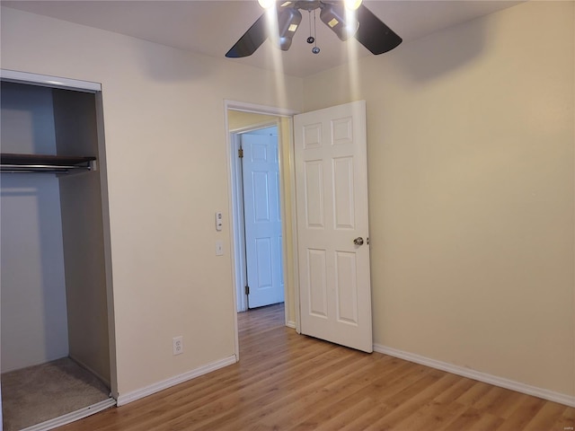 unfurnished bedroom featuring baseboards, a closet, a ceiling fan, and light wood-style floors