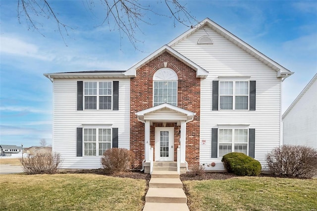 view of front of house with a front lawn and brick siding