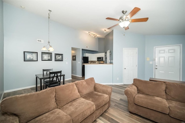 living room with visible vents, baseboards, ceiling fan, and wood finished floors