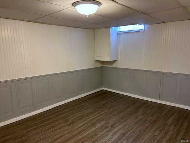 basement featuring dark hardwood / wood-style floors and a drop ceiling