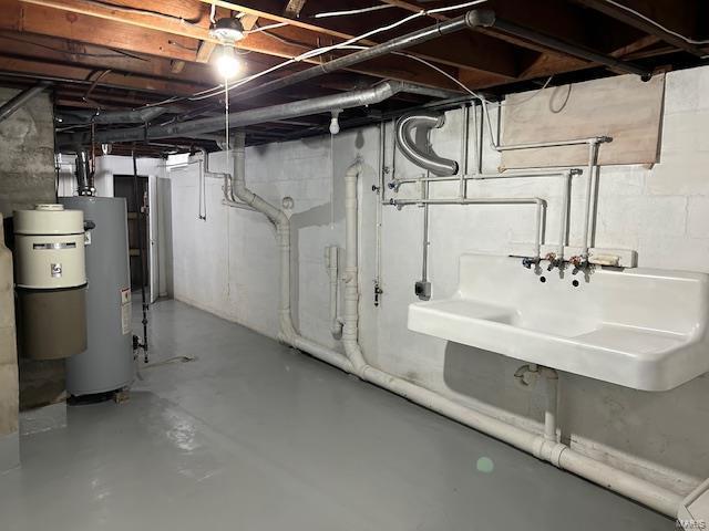 basement featuring gas water heater and sink