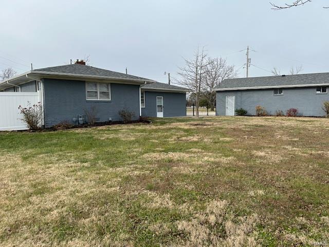 back of property featuring a lawn