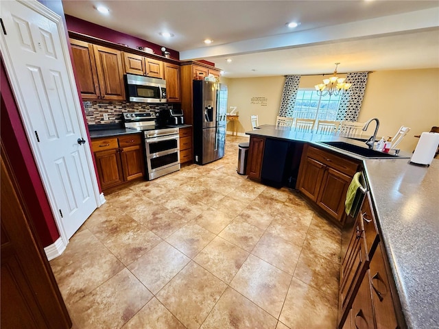 kitchen with sink, stainless steel appliances, a chandelier, decorative light fixtures, and decorative backsplash