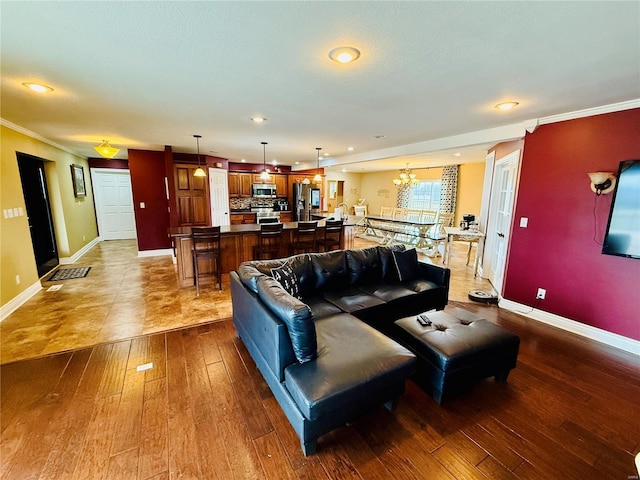 living room featuring ornamental molding, light hardwood / wood-style floors, and an inviting chandelier