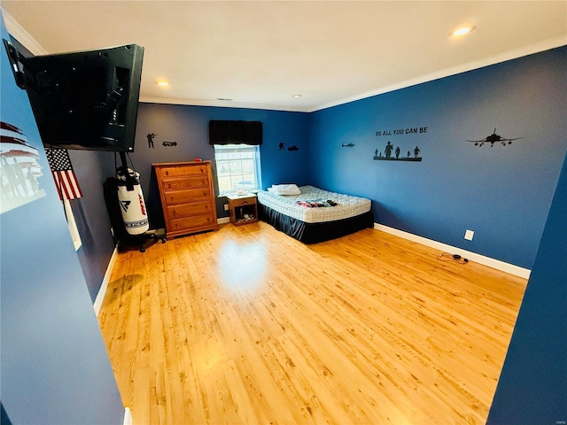 bedroom with wood-type flooring and crown molding