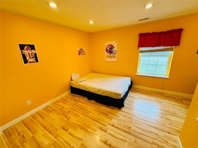 bedroom featuring wood-type flooring and crown molding