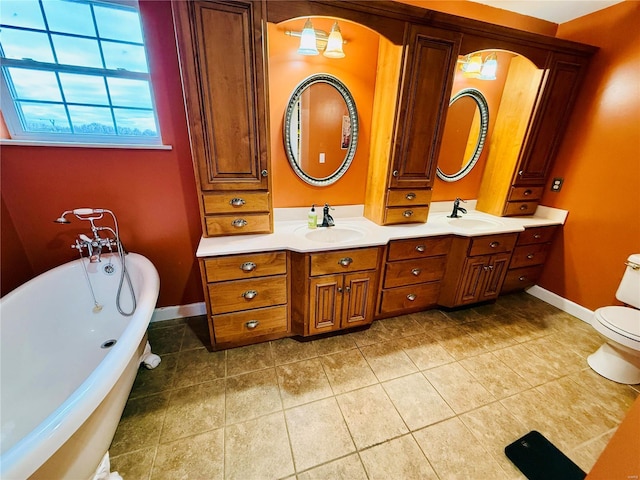 bathroom with tile patterned floors, vanity, a bath, and toilet