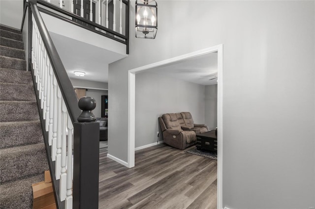 stairway with a notable chandelier and wood-type flooring