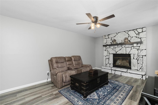 living room with ceiling fan, wood-type flooring, and a fireplace