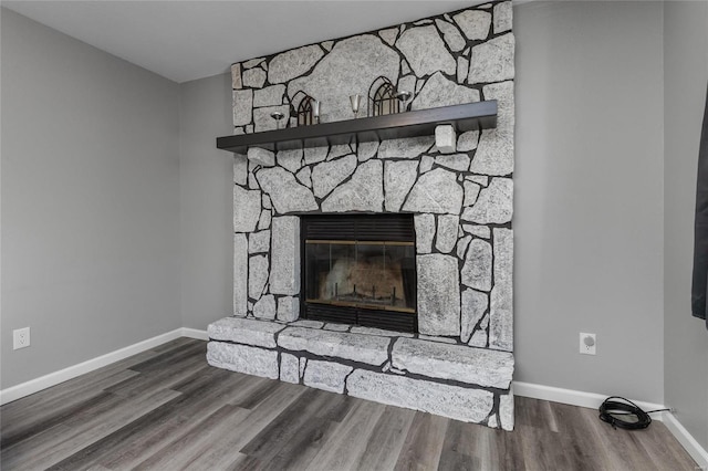 room details with a stone fireplace and hardwood / wood-style flooring