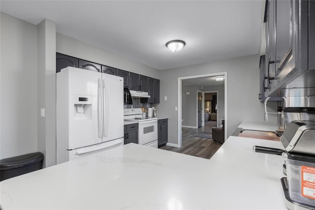 kitchen featuring kitchen peninsula, dark hardwood / wood-style flooring, and white appliances