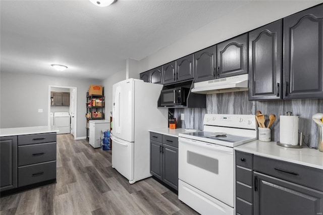 kitchen with white appliances, backsplash, dark hardwood / wood-style floors, independent washer and dryer, and a textured ceiling