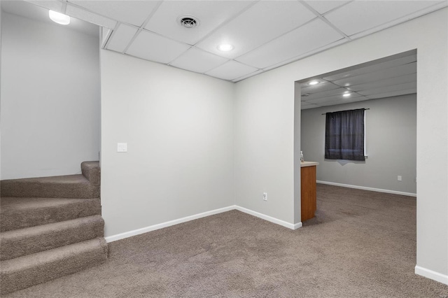 basement with carpet and a paneled ceiling