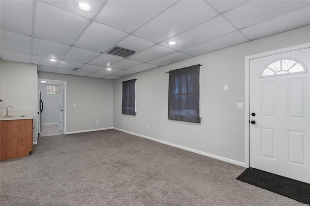 entrance foyer with sink, carpet floors, and a drop ceiling