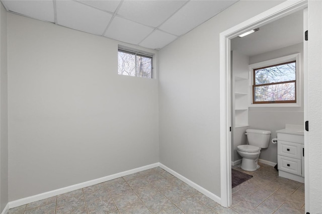 bathroom featuring a drop ceiling, vanity, and toilet