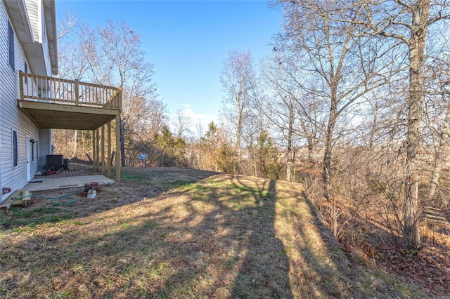 view of yard featuring a deck, cooling unit, and a patio area