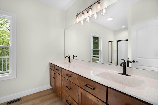 bathroom featuring hardwood / wood-style floors, vanity, and an enclosed shower