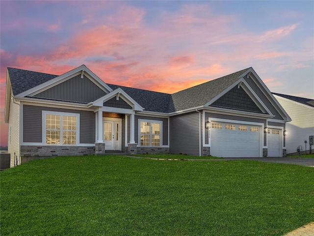 craftsman house featuring a garage and a yard