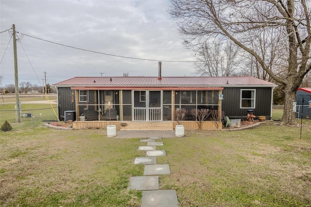 back of house with a sunroom, central air condition unit, and a lawn