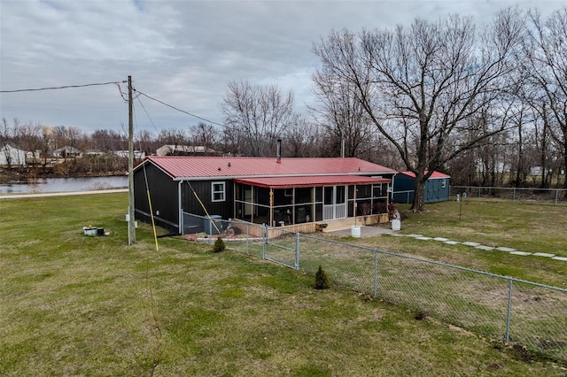 rear view of house with a yard and a water view