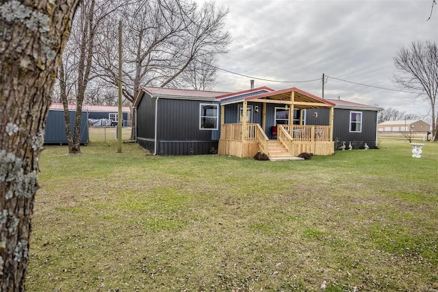 manufactured / mobile home with an outbuilding and a front yard