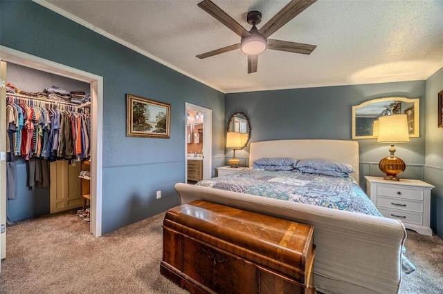 bedroom with ceiling fan, light colored carpet, connected bathroom, and a closet