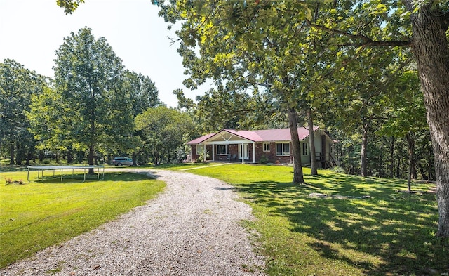 single story home featuring a front lawn and a trampoline