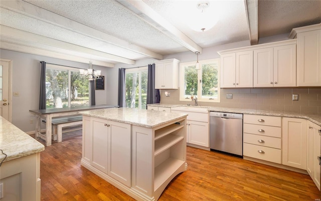 kitchen featuring decorative backsplash, pendant lighting, white cabinetry, dishwasher, and a kitchen island