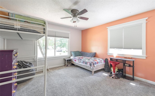 bedroom featuring carpet flooring, a textured ceiling, and ceiling fan