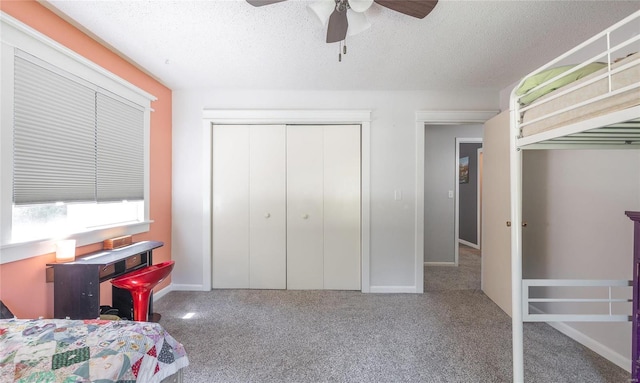 carpeted bedroom featuring a textured ceiling, a closet, and ceiling fan