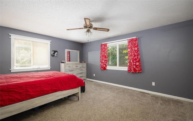 carpeted bedroom featuring a textured ceiling and ceiling fan