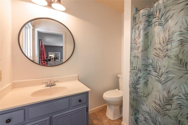 bathroom featuring vanity, toilet, and walk in shower