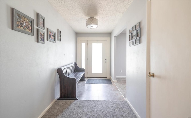 doorway featuring carpet and a textured ceiling