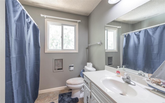 bathroom with vanity, a textured ceiling, toilet, and plenty of natural light