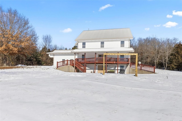 snow covered rear of property with a deck