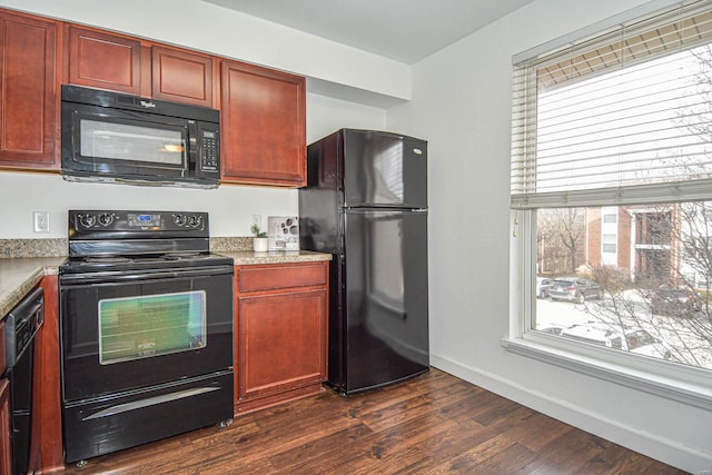 kitchen featuring dark hardwood / wood-style floors, a healthy amount of sunlight, and black appliances