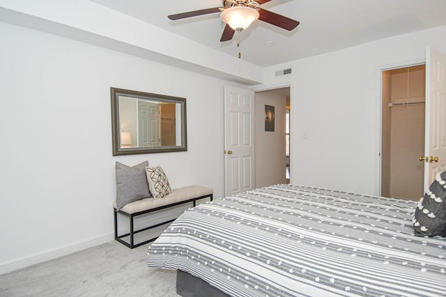 carpeted bedroom featuring a walk in closet, ceiling fan, and a closet