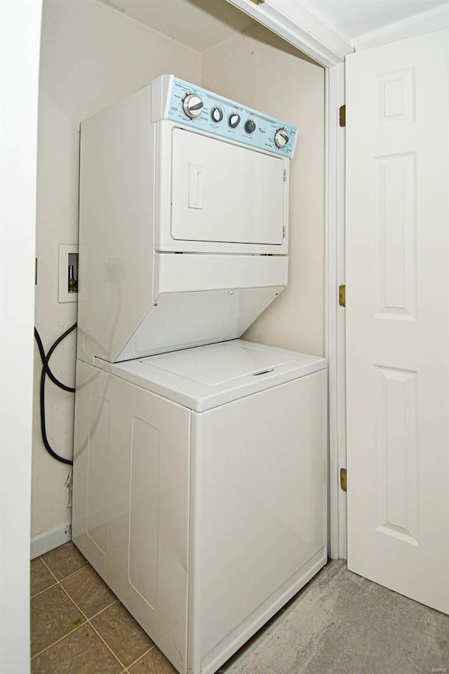 laundry room featuring stacked washer / drying machine