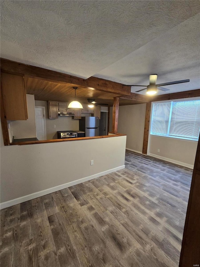 unfurnished living room with beamed ceiling, dark hardwood / wood-style floors, ceiling fan, and a textured ceiling