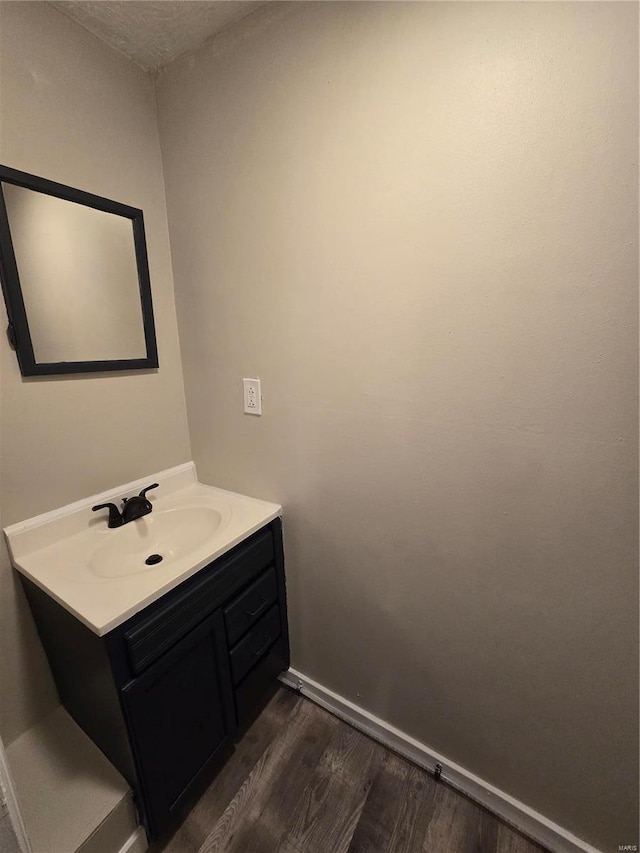 bathroom with hardwood / wood-style floors, vanity, and a textured ceiling