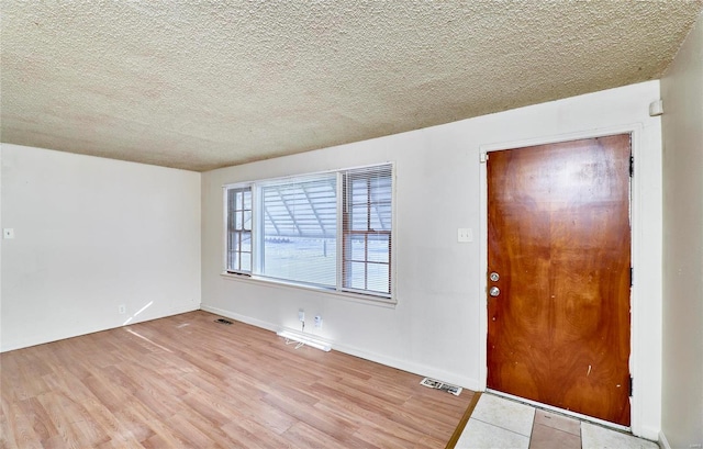 entrance foyer featuring light hardwood / wood-style floors and a textured ceiling