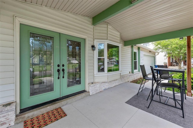 view of patio / terrace with french doors and a garage