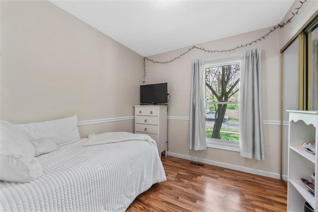 bedroom featuring wood-type flooring and vaulted ceiling