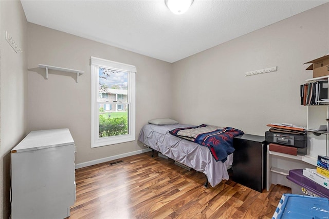 bedroom with hardwood / wood-style flooring