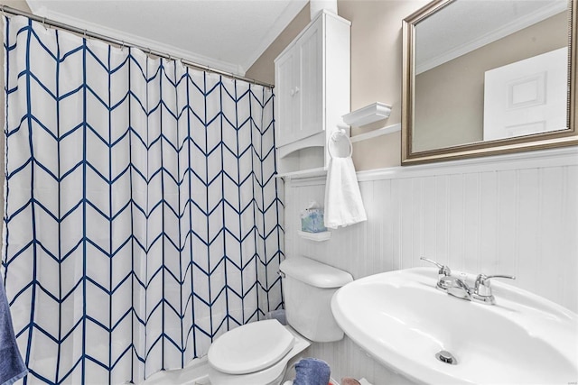 bathroom with crown molding, sink, a shower with shower curtain, and toilet