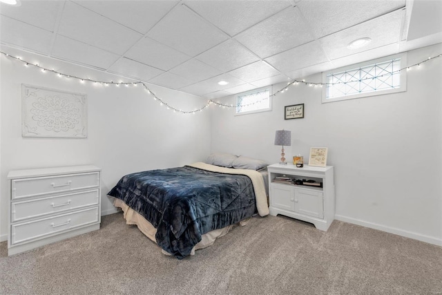 bedroom with light carpet and a paneled ceiling